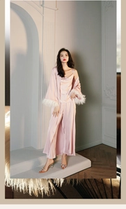 Detail of pink satin sleepwear set featuring luxurious white feather cuffs and silk texture