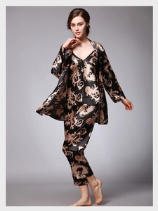 Détail d'un ensemble de pyjama en satin noir pour femme avec imprimé dragon doré et dentelle
