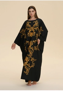 Detail of elegant black kaftan with intricate gold baroque floral patterns for women