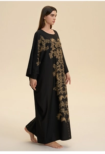 Detail of elegant gold floral embroidery on a black loose kaftan abaya for women
