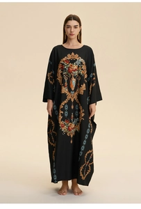 Detailed view of baroque floral print and gold scrollwork on black maxi kaftan dress