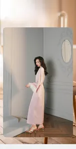 Pink satin long robe with luxurious white feather cuffs in a minimalist indoor setting