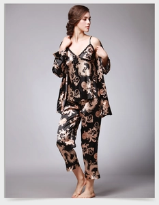 Détail de l'imprimé dragon baroque doré et dentelle noire sur pyjama en soie