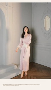 Luxurious pink silk robe detail featuring elegant white feather trim on the long sleeve cuffs