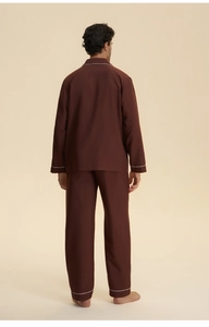 Back view of men's dark brown cotton pajamas featuring white piping details