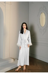 Close-up of elegant satin robe with luxurious feather cuffs and matching waist tie