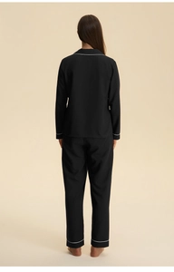 Back view of a black long-sleeve loungewear set with elegant white piping details