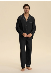 Close-up of men's black cotton pajamas set featuring classic white piping and buttons