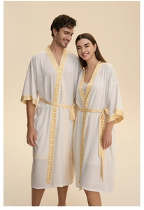 Détail de peignoirs de couple en satin blanc avec motifs jaunes et fermeture à la taille