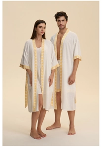 Détails de peignoirs en coton blanc avec des motifs géométriques jaunes sur les bords