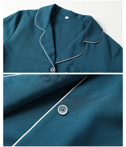 Detail of dark teal pajama top with white piping, chest pocket and classic button collar