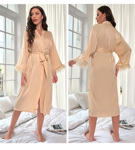 Champagne gold satin robe with elegant feather trim on sleeves and adjustable waist tie