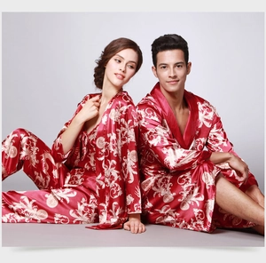 Détail d'un pyjama en soie rouge avec motif baroque doré sur un tissu satiné lisse
