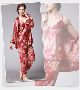 Détail du pyjama en soie glacée bordeaux avec motif paisley doré et bordure en dentelle