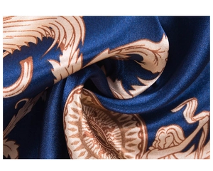Gros plan détaillé du tissu en soie bleu foncé avec motifs baroques dorés et textures