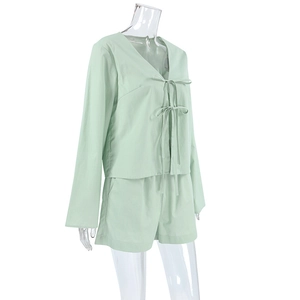 Detail of light green cotton pajamas set with V-neck lace-up top and side pocket shorts