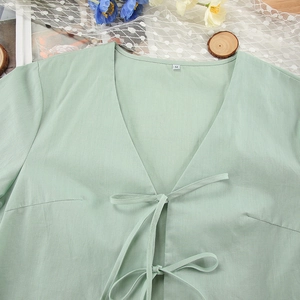 Close-up of light green cotton pajama top with double bow ties and V-neck detail