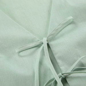 Detail of light green cotton pajama top showing tie-up closure and soft fabric texture