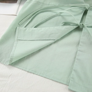 Detail view of mint green cotton pajamas featuring side-tie closure and hem stitching