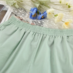 Close-up of mint green pajama shorts with elastic waistband and cotton linen texture