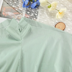 Detail of light green cotton pajama neckline with high-quality stitching and fabric texture