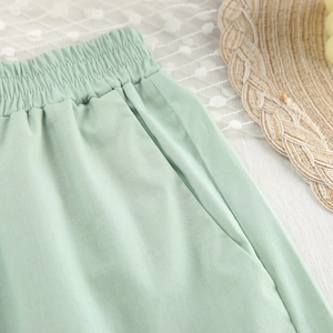 Detail of mint green cotton lounge shorts with elastic waist and side pockets