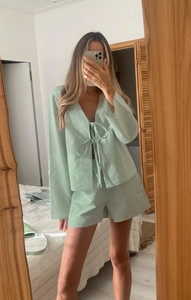 Detail of mint green cotton lounge set showing the tie-front closure and texture