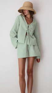 Detail of mint green cotton lounge set with tie-front long sleeves and high waist shorts