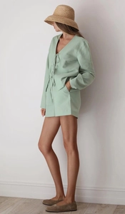 Detail view of light green cotton loungewear featuring V-neck top and shorts with pockets