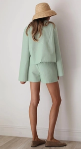 Rear view of minimalist light green cotton pajamas set with long sleeve top and shorts