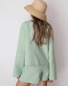 Rear view of light green cotton pajamas set with natural fabric texture and straw hat