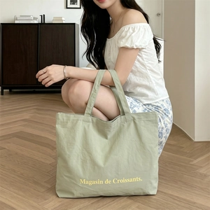 Detalle del bolso tote de lona verde salvia con el estampado Magasin de Croissants