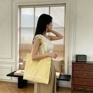 Bolso tote grande de lona amarillo pálido con estampado Magasin de Croissants al hombro