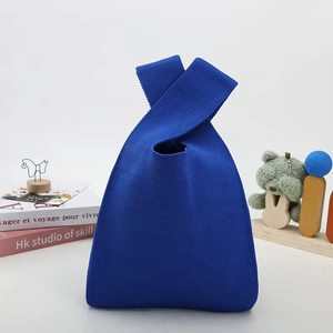 Detail of royal blue knitted handbag featuring chunky mesh texture and triangular design