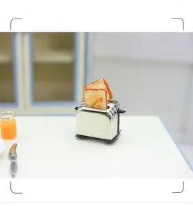 Detailed macro view of a dollhouse miniature toaster with toast slices and tiny accessories