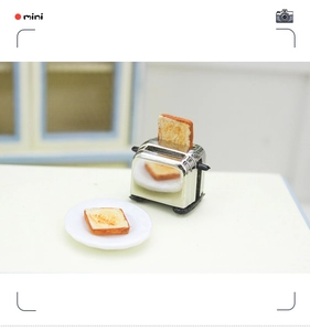 Detailed macro view of miniature silver toaster with realistic toast slices and white tray