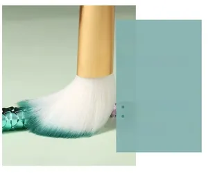 Macro detail of gradient mermaid makeup brush bristles with gold ferrule and scales