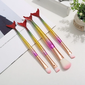 Detail view of gradient mermaid tail makeup brushes with textured scales and soft bristles