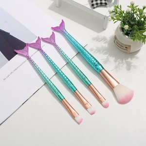 Detail of mermaid-tail makeup brushes with gradient handles and soft dual-tone bristles