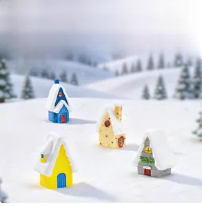Detailed view of four miniature resin Christmas snow houses with thick snowy roofs