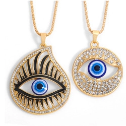 Détail des colliers œil porte-bonheur dorés avec des pierres bleues et zircons blancs