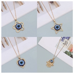 Détails de quatre pendentifs œil bleu dorés avec formes de main de Hamsa, cœur et étoile