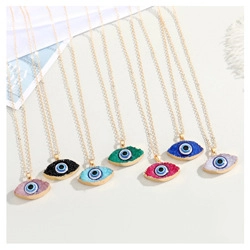 Vue à plat de sept colliers avec pendentifs œil maléfique colorés et chaînes dorées élégantes