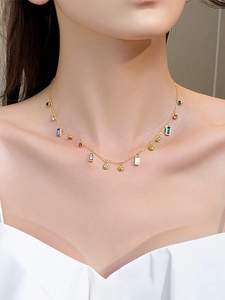 Close-up of gold titanium necklace with colorful rectangular and round zircon stones