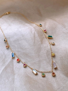 Detailed close-up of gold titanium necklace with colorful zircon stone charms