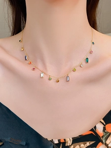 Close-up of titanium steel gold necklace with colorful zircon gemstones on model
