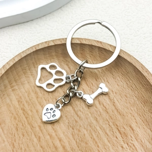 Polished pet memorial keychain with dog bone, paw print and heart charms on wood tray
