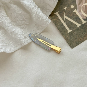 Elegant grey iridescent acetate duckbill hair clip with golden metal base on lace