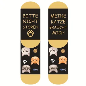 Mid-calf socks featuring cat patterns and German text on black and yellow cotton blend