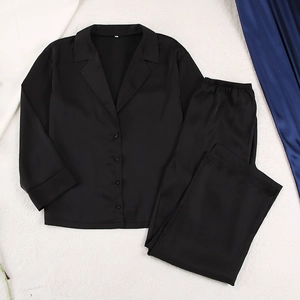 Détail d'un pyjama en satin noir montrant le col à revers classique et la texture soie